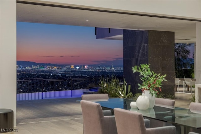 patio terrace at dusk with a balcony and outdoor dining space