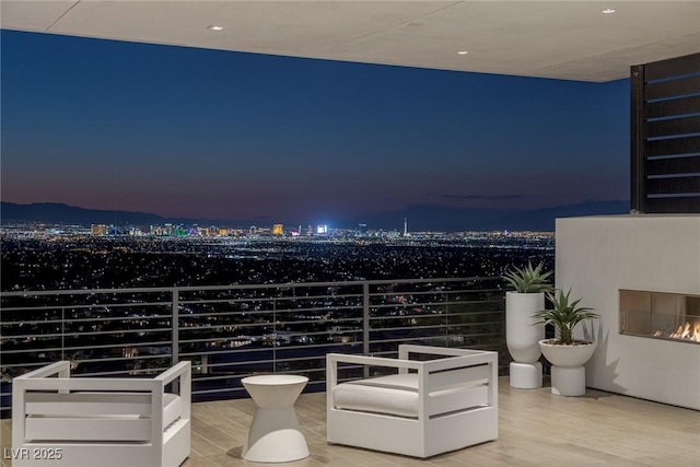 interior space with a balcony and a view of city lights