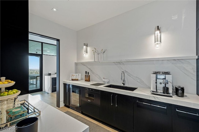 kitchen featuring dark cabinets, a sink, light countertops, modern cabinets, and tasteful backsplash