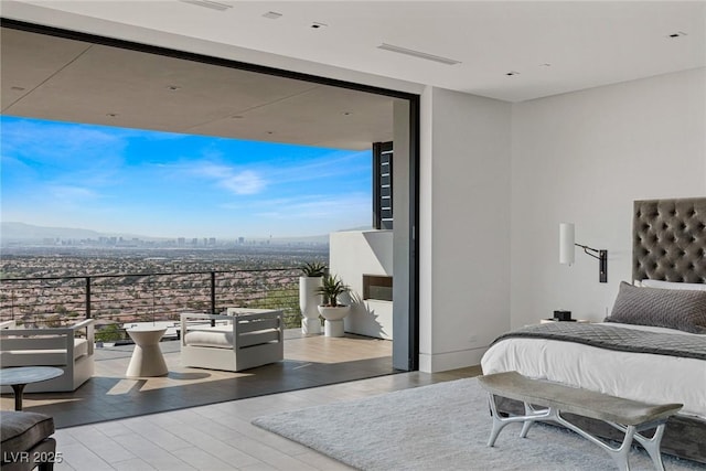 bedroom featuring a wall of windows, a city view, and wood finished floors