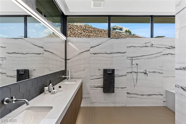 bathroom featuring a sink, a marble finish shower, double vanity, and tile patterned floors