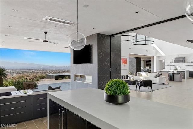 kitchen with visible vents, ceiling fan, light countertops, open floor plan, and dark cabinets