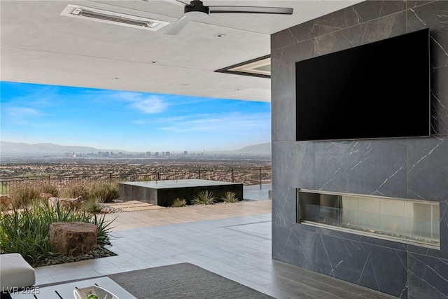 view of patio / terrace featuring a mountain view, fence, visible vents, and ceiling fan