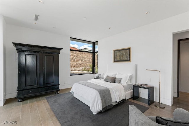 bedroom with recessed lighting, visible vents, light wood-style flooring, and baseboards