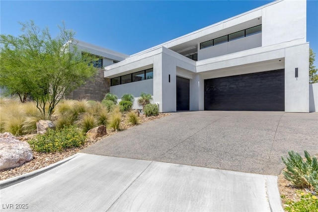 modern home featuring stucco siding, a garage, and concrete driveway