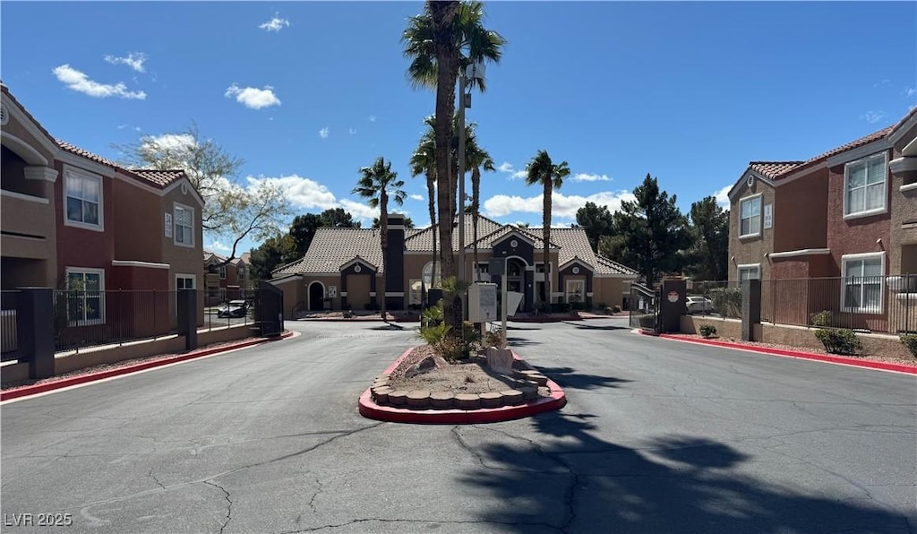 view of street with a residential view, a gated entry, and curbs