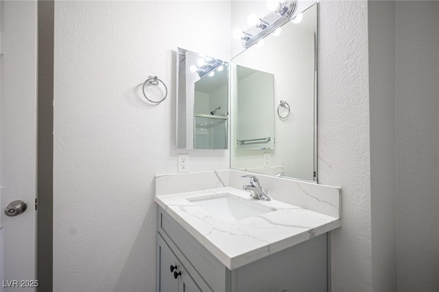 bathroom featuring a textured wall and vanity