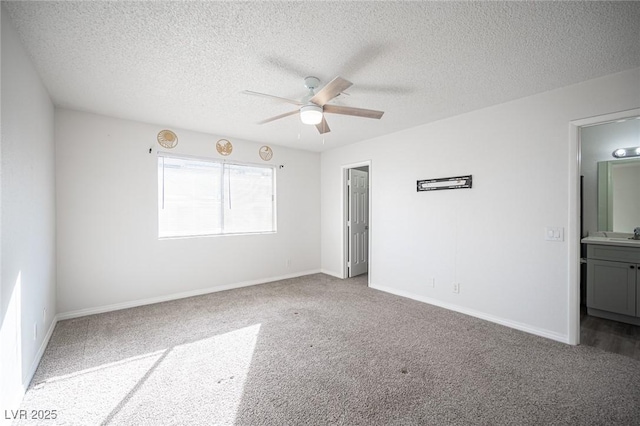 carpeted spare room with ceiling fan, a textured ceiling, and baseboards