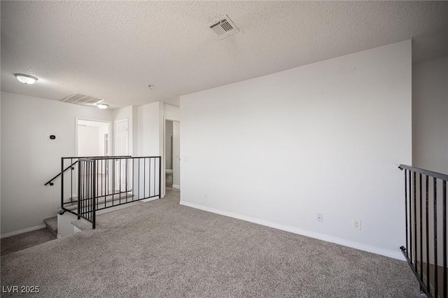 empty room with baseboards, a textured ceiling, visible vents, and carpet flooring