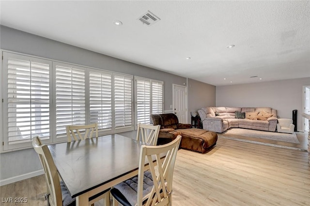 dining area with a healthy amount of sunlight, visible vents, and wood finished floors