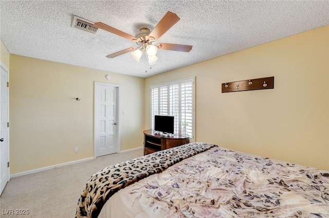 carpeted bedroom with a textured ceiling, ceiling fan, visible vents, and baseboards