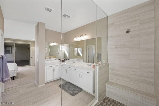 ensuite bathroom featuring ensuite bathroom, a sink, visible vents, double vanity, and walk in shower