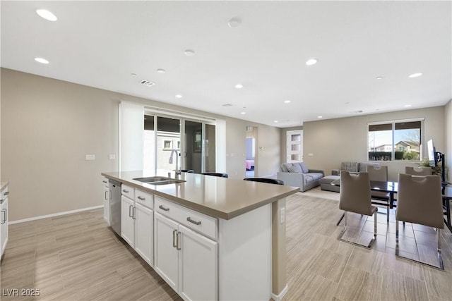 kitchen featuring a center island with sink, a sink, dishwasher, and recessed lighting