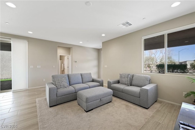 living room with light wood-type flooring, baseboards, visible vents, and recessed lighting