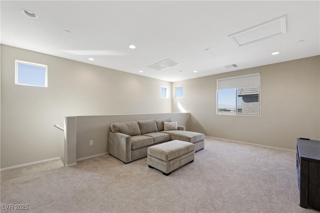 living area with light colored carpet, a wealth of natural light, visible vents, and recessed lighting