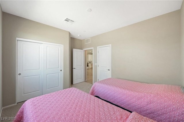 bedroom featuring light carpet, a closet, and visible vents