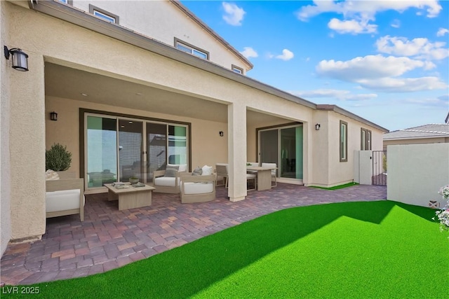 back of property featuring a patio area and stucco siding