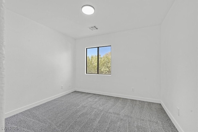 empty room featuring carpet floors, visible vents, and baseboards