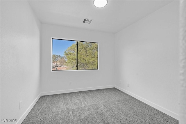 spare room featuring carpet floors, visible vents, and baseboards