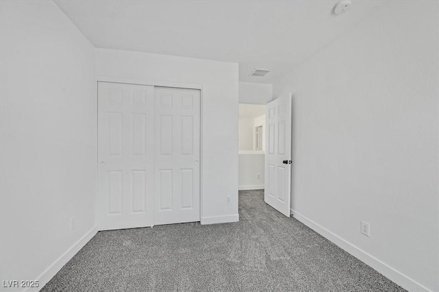 unfurnished bedroom with carpet floors, baseboards, visible vents, and a closet