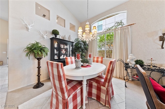 dining room with high vaulted ceiling and a notable chandelier