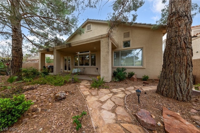 back of house with a patio area and stucco siding