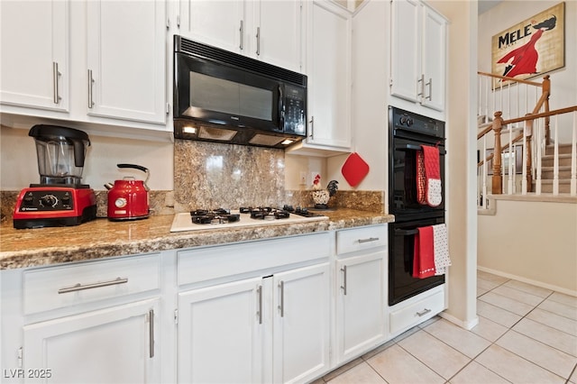 kitchen featuring light tile patterned floors, baseboards, decorative backsplash, black appliances, and white cabinetry