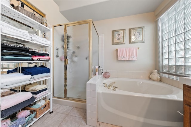 full bath with a spacious closet, a stall shower, tile patterned flooring, and a bath