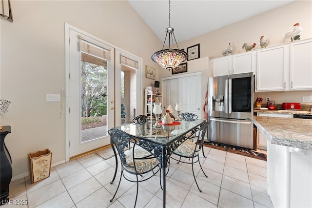 dining area with lofted ceiling, light tile patterned floors, baseboards, and french doors