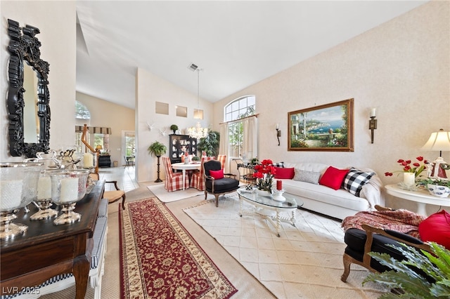 living area featuring high vaulted ceiling, visible vents, and a notable chandelier