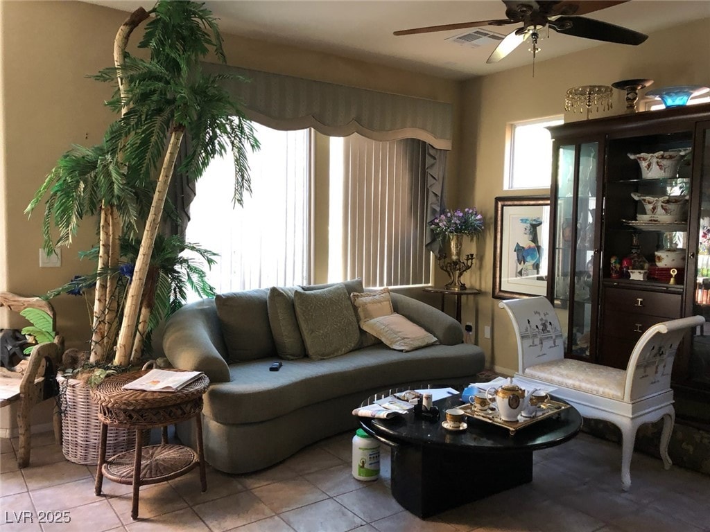 tiled living room featuring visible vents and a ceiling fan