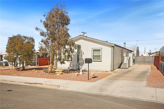 view of front of home featuring fence and concrete driveway