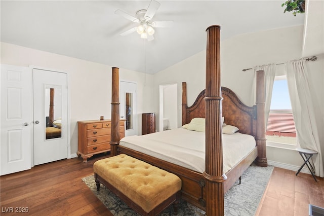 bedroom with vaulted ceiling, wood finished floors, visible vents, and baseboards