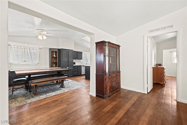 kitchen with vaulted ceiling, dark wood-style flooring, a sink, and visible vents