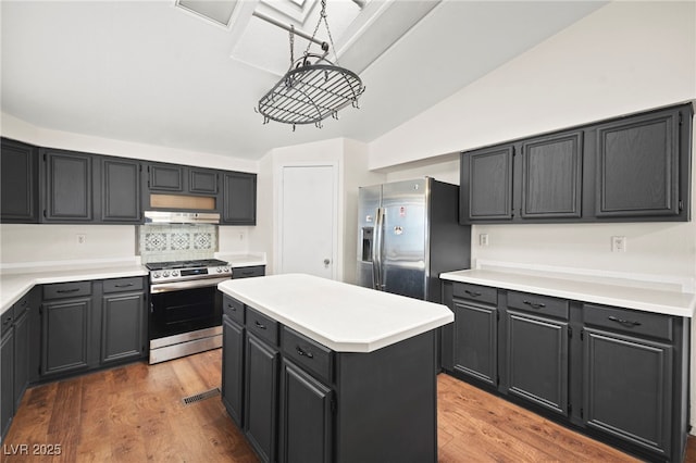 kitchen featuring appliances with stainless steel finishes, light wood-type flooring, a center island, and light countertops