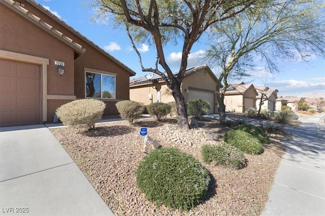 view of front of property featuring a tiled roof, an attached garage, and stucco siding