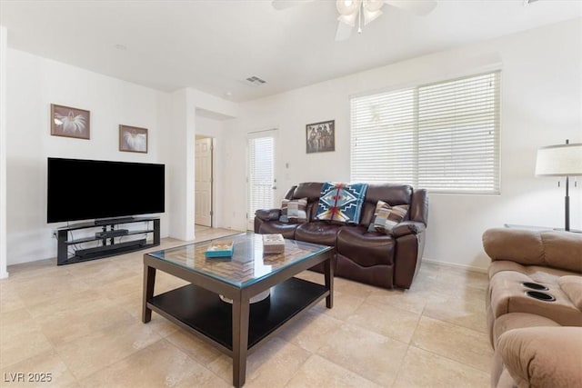 living area featuring a wealth of natural light, visible vents, a ceiling fan, and light tile patterned flooring