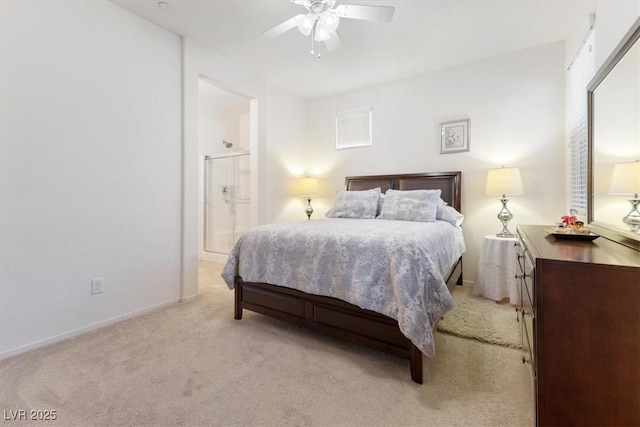 bedroom featuring light carpet, ceiling fan, baseboards, and ensuite bathroom