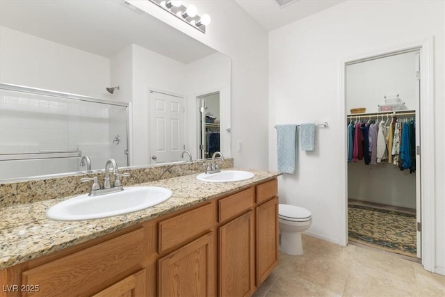 full bath with double vanity, a stall shower, toilet, and a sink