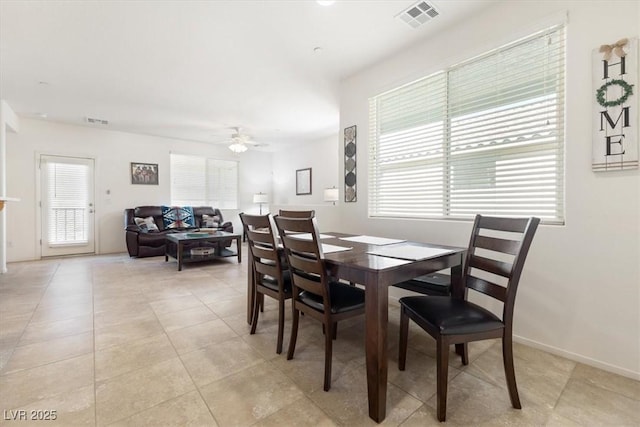 dining room featuring a ceiling fan, visible vents, baseboards, and light tile patterned flooring