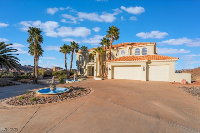 mediterranean / spanish-style house featuring driveway, an attached garage, a tiled roof, and stucco siding