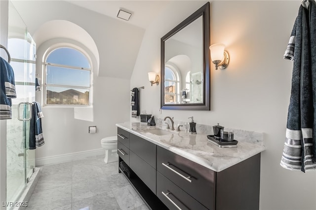 bathroom with baseboards, toilet, vaulted ceiling, vanity, and a shower stall