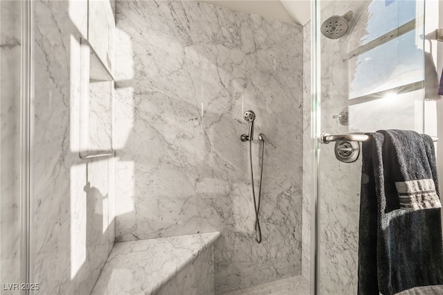 bathroom featuring a marble finish shower