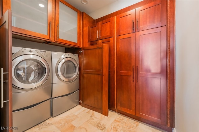 clothes washing area with cabinet space and separate washer and dryer