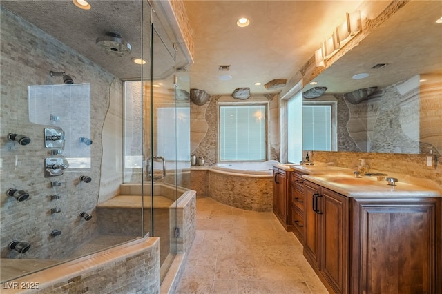 bathroom with visible vents, a garden tub, a shower stall, and double vanity