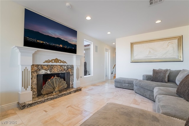 living area featuring a premium fireplace, recessed lighting, visible vents, and baseboards