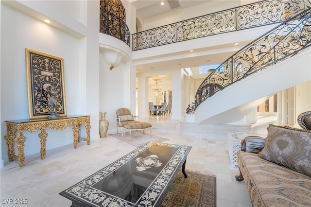 interior space with baseboards, stairway, a towering ceiling, and an inviting chandelier