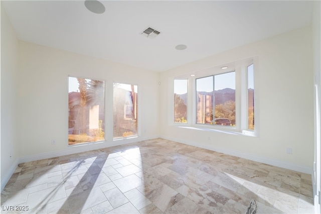 unfurnished room with visible vents and baseboards