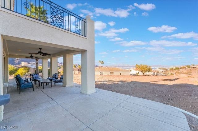 view of patio featuring a balcony, an outdoor hangout area, and a ceiling fan