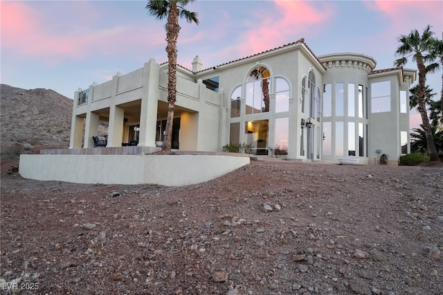 rear view of house featuring a mountain view and stucco siding